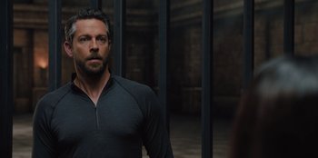 Movie still from “Spy Kids: Armageddon” (2023), directed by Robert Rodriguez – A man standing in front of a metal fence; Close Up shot, Over the shoulder angle