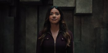 Movie still from “Spy Kids: Armageddon” (2023), directed by Robert Rodriguez – A woman with long brown hair standing in front of a building; Close Up shot, Low angle