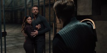 Movie still from “Spy Kids: Armageddon” (2023), directed by Robert Rodriguez – A man and a woman standing next to each other in front of another man; Medium shot, Over the shoulder angle