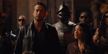 Movie still from “Spy Kids: Armageddon” (2023), directed by Robert Rodriguez – A group of people standing next to each other in a room; Close Up shot, Over the shoulder angle