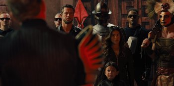 Movie still from “Spy Kids: Armageddon” (2023), directed by Robert Rodriguez – A group of people standing next to each other in a room; Close Up shot, Over the shoulder angle