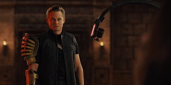 Movie still from “Spy Kids: Armageddon” (2023), directed by Robert Rodriguez – A man standing in front of a microphone in a dark room; Medium shot, Low angle
