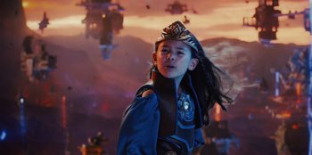 Movie still from “Spy Kids: Armageddon” (2023), directed by Robert Rodriguez – A young girl wearing a crown in front of an orange sky; Medium shot, Low angle
