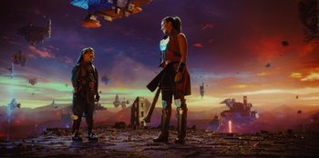 Movie still from “Spy Kids: Armageddon” (2023), directed by Robert Rodriguez – A woman and a man standing on a field; Wide shot, Over the shoulder angle