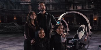 Movie still from “Spy Kids: Armageddon” (2023), directed by Robert Rodriguez – A man and two girls posing for a picture; Medium shot, Low angle