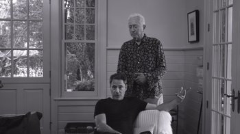 A man sitting in a chair next to an older man