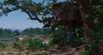 Movie still from “Stand by Me” (1986), directed by Rob Reiner – A person standing on a ladder next to a tree house; Extreme Wide shot, Low angle