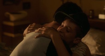 Movie still from “Stand by Me” (1986), directed by Rob Reiner – A young boy is hugging a pillow while wearing a baseball cap; Close Up shot, Over the shoulder angle
