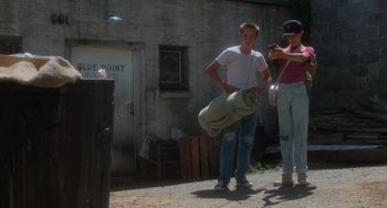 Movie still from “Stand by Me” (1986), directed by Rob Reiner – A man and woman standing in front of a building; Wide shot, Low angle