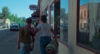 Movie still from “Stand by Me” (1986), directed by Rob Reiner – Two people walking down the sidewalk of a street; Wide shot, Over the shoulder angle