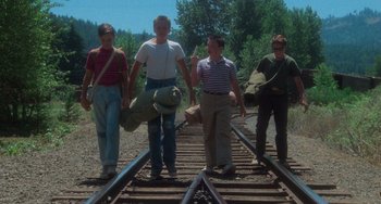 Movie still from “Stand by Me” (1986), directed by Rob Reiner – A group of people standing on top of a train track; Wide shot, Low angle