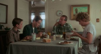 Movie still from “Stand by Me” (1986), directed by Rob Reiner – Two men sitting at a dinner table eating food; Wide shot, Low angle