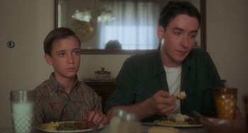 Movie still from “Stand by Me” (1986), directed by Rob Reiner – Two young men sitting at a table eating food; Medium shot, Over the shoulder angle