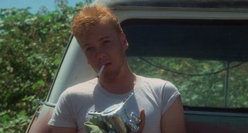 Movie still from “Stand by Me” (1986), directed by Rob Reiner – A man with a cigarette in his mouth and holding a drink in his hand; Close Up shot, Low angle