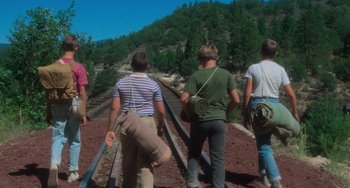Movie still from “Stand by Me” (1986), directed by Rob Reiner – A group of people walking along a train track; Wide shot, Low angle