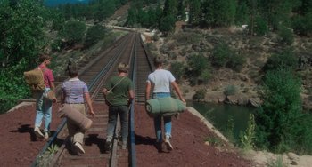 Movie still from “Stand by Me” (1986), directed by Rob Reiner – A group of people walking across a train track; Wide shot, High angle