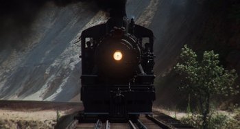 Movie still from “Stand by Me” (1986), directed by Rob Reiner – A train traveling down train tracks next to a forest; Extreme Wide shot, Low angle