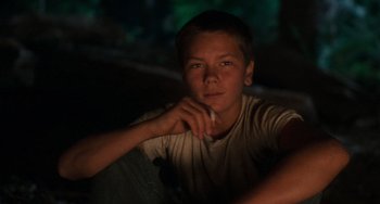 Movie still from “Stand by Me” (1986), directed by Rob Reiner – A young man sitting in a dark room; Close Up shot, High angle