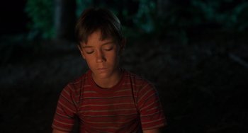 Movie still from “Stand by Me” (1986), directed by Rob Reiner – A young boy sitting in the dark with his eyes closed; Close Up shot, High angle