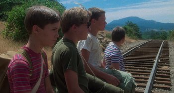 Movie still from “Stand by Me” (1986), directed by Rob Reiner – A group of young men sitting on top of train tracks; Medium shot, Low angle