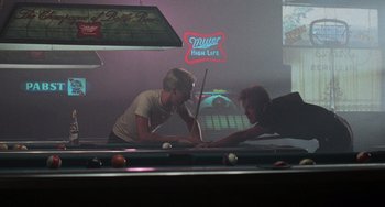 Movie still from “Stand by Me” (1986), directed by Rob Reiner – Two people playing pool in a bar with neon lights; Wide shot, Over the shoulder angle