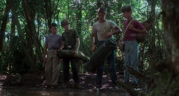 Movie still from “Stand by Me” (1986), directed by Rob Reiner – A group of young men standing in the woods; Wide shot, Low angle