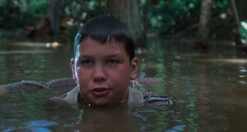 Movie still from “Stand by Me” (1986), directed by Rob Reiner – A young boy is swimming in a body of water; Close Up shot, High angle
