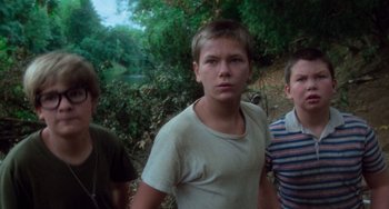 Movie still from “Stand by Me” (1986), directed by Rob Reiner – Three young boys standing next to each other in a wooded area; Medium shot, Low angle