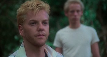 Movie still from “Stand by Me” (1986), directed by Rob Reiner – A man with blonde hair standing next to another man; Close Up shot, Over the shoulder angle