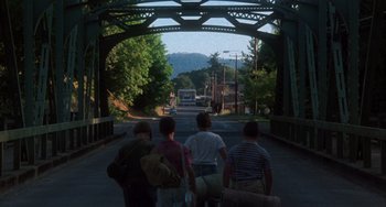 Movie still from “Stand by Me” (1986), directed by Rob Reiner – A group of people walking across a bridge; Wide shot, High angle