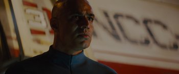 Movie still from “Star Trek” (2009), directed by J.J. Abrams – A man with a bald head wearing a blue shirt; Close Up shot, Low angle