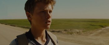 Movie still from “Star Trek” (2009), directed by J.J. Abrams – A young man standing on a dirt road near a field; Close Up shot, Low angle