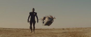 Movie still from “Star Trek” (2009), directed by J.J. Abrams – A man in a black suit is standing in the dirt; Wide shot, Low angle