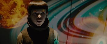 Movie still from “Star Trek” (2009), directed by J.J. Abrams – A young man with a short hair cut stands in front of an image; Close Up shot, Over the shoulder angle