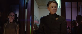 Movie still from “Star Trek” (2009), directed by J.J. Abrams – A man wearing a star trek uniform standing in front of a mirror; Medium shot, Over the shoulder angle