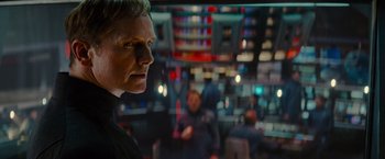 Movie still from “Star Trek” (2009), directed by J.J. Abrams – A man standing in front of other people in a room; Close Up shot, Over the shoulder angle