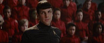 Movie still from “Star Trek” (2009), directed by J.J. Abrams – A man in a black shirt and some people behind him; Close Up shot, Over the shoulder angle