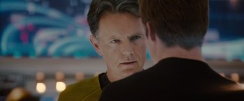 Movie still from “Star Trek” (2009), directed by J.J. Abrams – A man in a star trek uniform looking at another man; Close Up shot, Over the shoulder angle