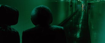 Movie still from “Star Trek” (2009), directed by J.J. Abrams – A person wearing a fur coat and a hat is sitting in a dark room; Wide shot, Over the shoulder angle