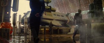 Movie still from “Star Trek” (2009), directed by J.J. Abrams – A man in a suit and tie standing in front of an airplane in a hangar; Extreme Wide shot, Low angle