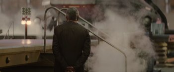 Movie still from “Star Trek” (2009), directed by J.J. Abrams – A man in a black suit standing next to a staircase; Medium shot, Over the shoulder angle