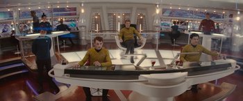 Movie still from “Star Trek” (2009), directed by J.J. Abrams – Two men in yellow shirts are sitting in a room; Wide shot, High angle