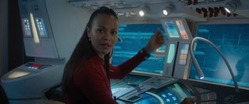 Movie still from “Star Trek Beyond” (2016), directed by Justin Lin – A woman in a red shirt in front of computer screens; Close Up shot, Over the shoulder angle