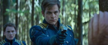 Movie still from “Star Trek Beyond” (2016), directed by Justin Lin – A man holding a gun while standing next to a forest; Close Up shot, Over the shoulder angle