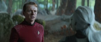 Movie still from “Star Trek Beyond” (2016), directed by Justin Lin – A man wearing a red shirt standing in front of a forest; Close Up shot, Over the shoulder angle