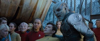 Movie still from “Star Trek Beyond” (2016), directed by Justin Lin – A group of people standing around each other in front of a wall; Medium shot, Over the shoulder angle
