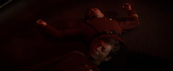 Movie still from “Star Trek II: The Wrath of Khan” (1982), directed by Nicholas Meyer – Two men laying on the ground in a dark room; Medium shot, Overhead angle