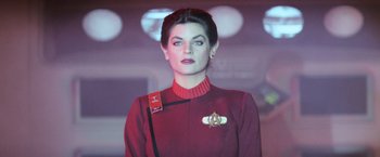 Movie still from “Star Trek II: The Wrath of Khan” (1982), directed by Nicholas Meyer – A woman wearing a red uniform and a star trek badge; Close Up shot, Low angle