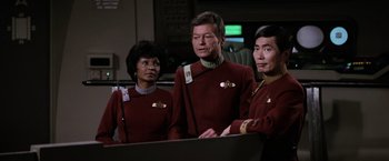 Movie still from “Star Trek II: The Wrath of Khan” (1982), directed by Nicholas Meyer – A group of people standing next to each other on top of a table; Medium shot, Over the shoulder angle