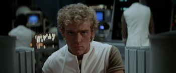 Movie still from “Star Trek II: The Wrath of Khan” (1982), directed by Nicholas Meyer – A young man with blonde curly hair is looking at the camera; Close Up shot, Over the shoulder angle